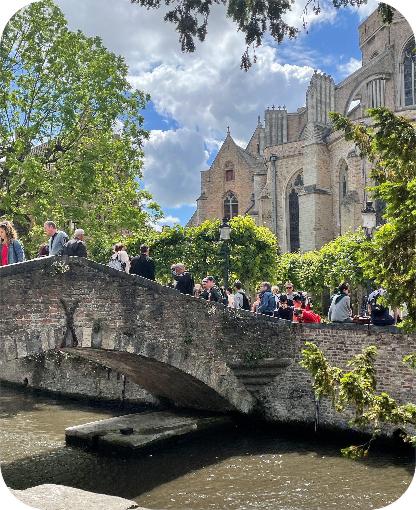 Tourists walk over the St. Bonafacius bridge, Bruges, Belgium