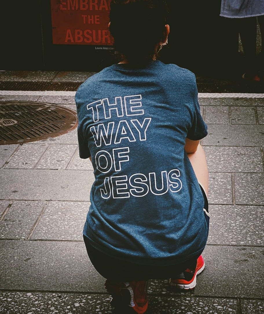 woman in blue and white crew neck t-shirt and black pants standing on gray concrete