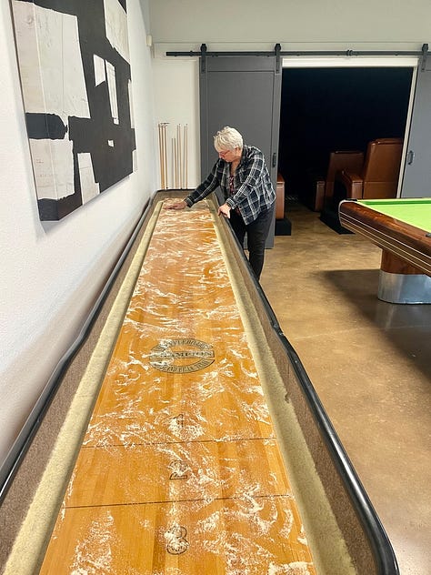 photo of Jill getting the shuffleboard ready for play and her and i playing.