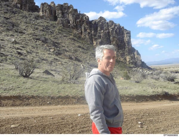 Jeffrey Epstein posing near jagged rock formations by a mountainous landscape.
