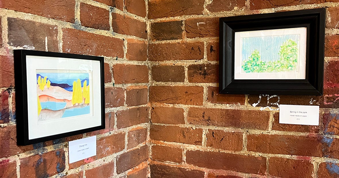 a photo of two artworks on the wall, both of landscapes a photo of two artworks on the wall, both of landscapes