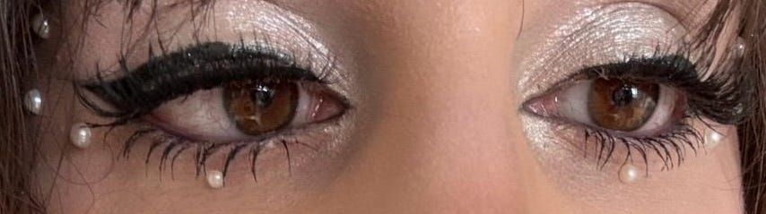An extreme close-up of Gia’s eyes, demonstrating the precise application of the Magic Flik eyeliner and the placement of adhesive pearls for a mermaid-inspired finish.