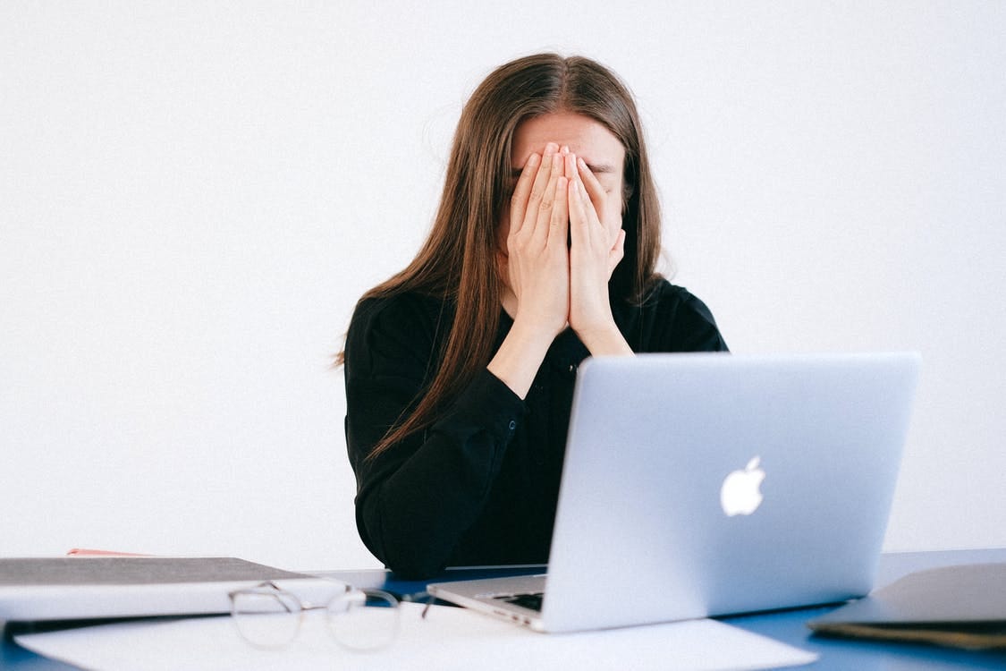 Woman With Hands on her Face in front of a Laptop Woman With Hands on her Face in front of a Laptop