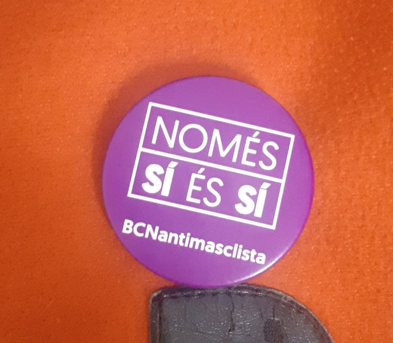 Una spilletta viola con la scritta "Nomes sí és sí - BCNantimasclista"