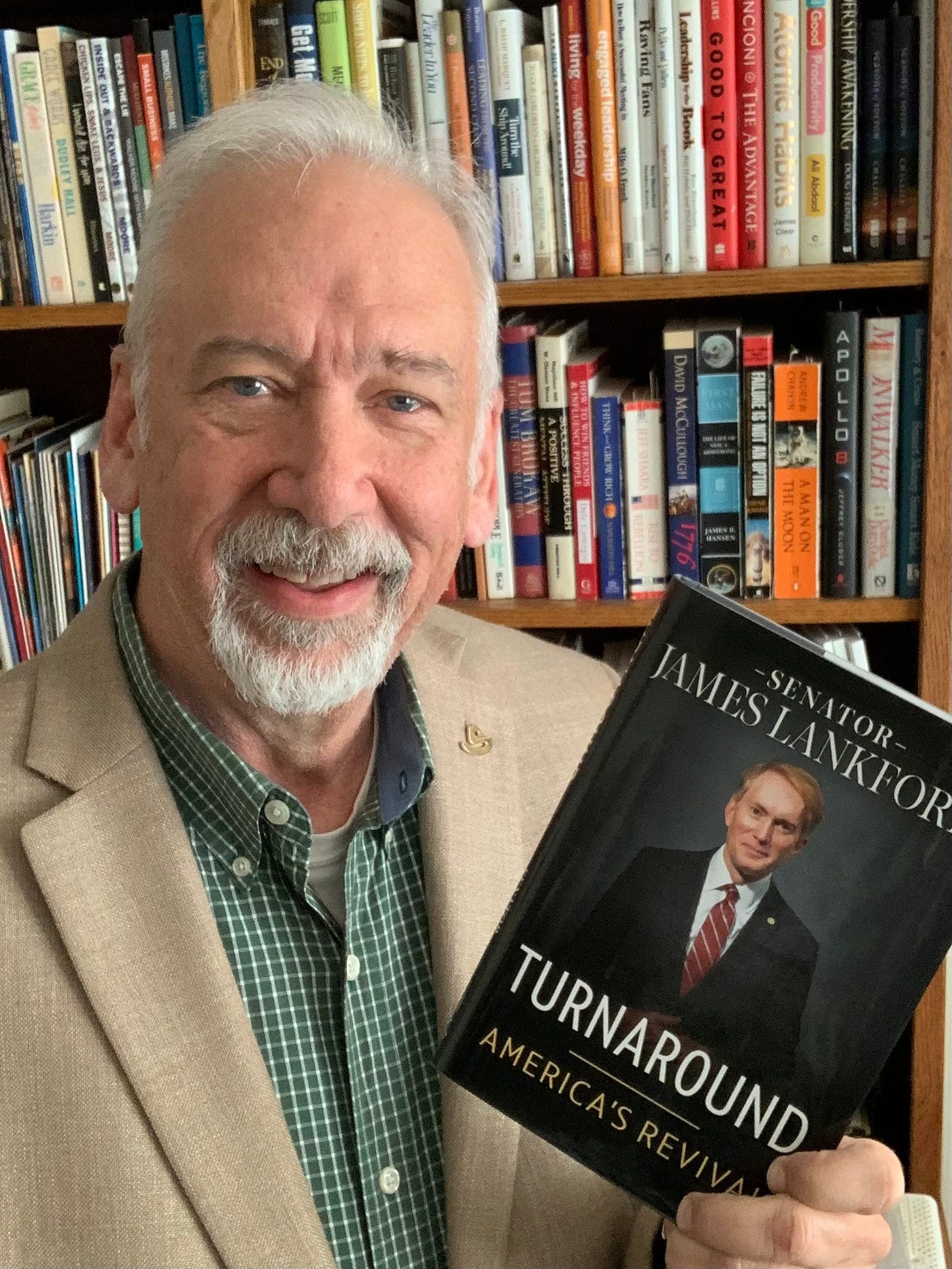 Image of a man holding Senator James Lankford's book, TURNAROUND: America's Revival.
