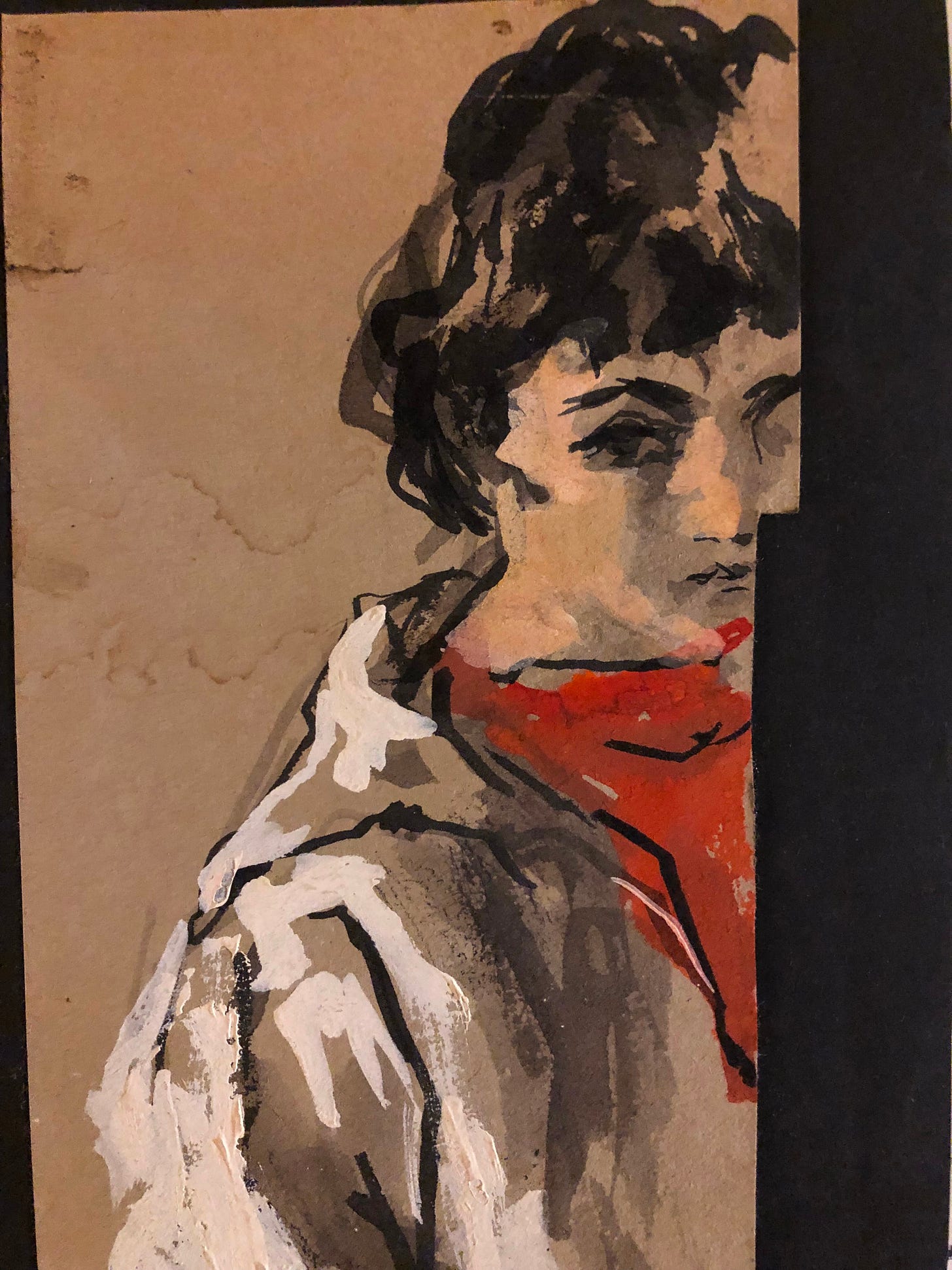 A crude self portrait by a woman in red and black and white, the paper cut so that the face is incomplete.