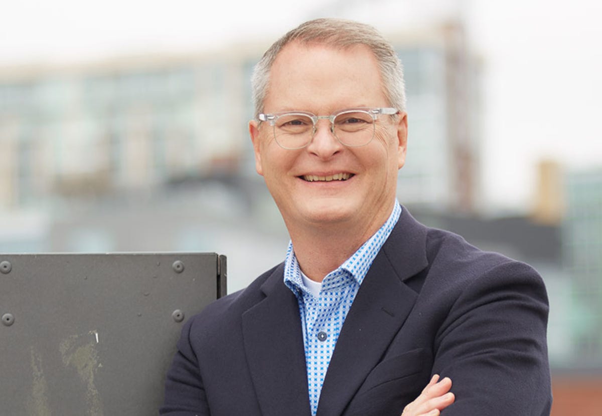 Candidate Adam Hamilton wearing a suit jacket over an unbuttoned collared shirt Candidate Adam Hamilton wearing a suit jacket over an unbuttoned collared shirt