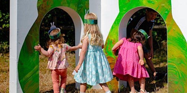 kids walking through large pages from the Very Hungry Caterpillar