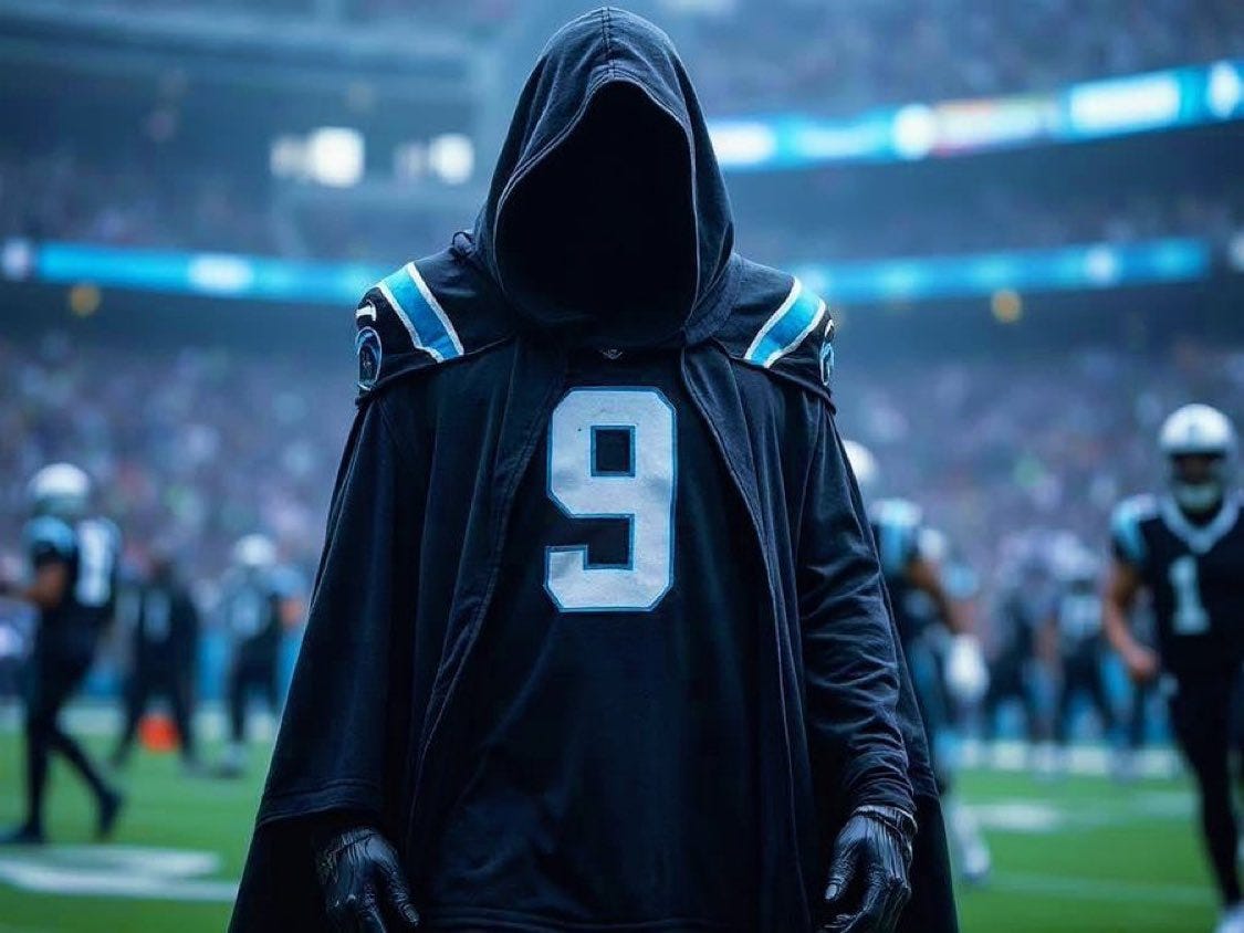 A figure wearing a black hooded cloak over a Carolina Panthers jersey with the number 9. The jersey has blue and silver accents on the shoulders. The figure stands on a football field with a blurred crowd and players in the background, some wearing Panthers uniforms.