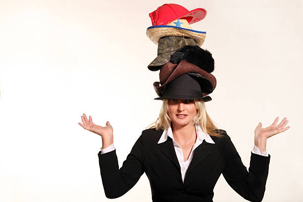 Business woman balancing life having to wear too many hats In todays busy world, many of us have to wear many hats.  Having to be a business woman,put out fires,hunt for  leads,play like a kid, and many of things. wearing multiple hats stock pictures, royalty-free photos & images