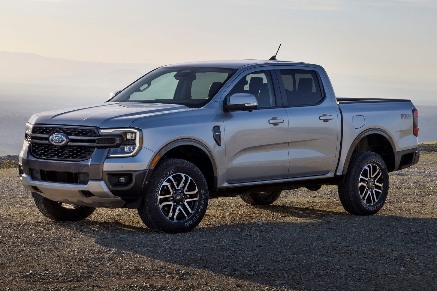 A silver 2024 Ford Ranger Lariat with the FX4 package is parked on gravel.