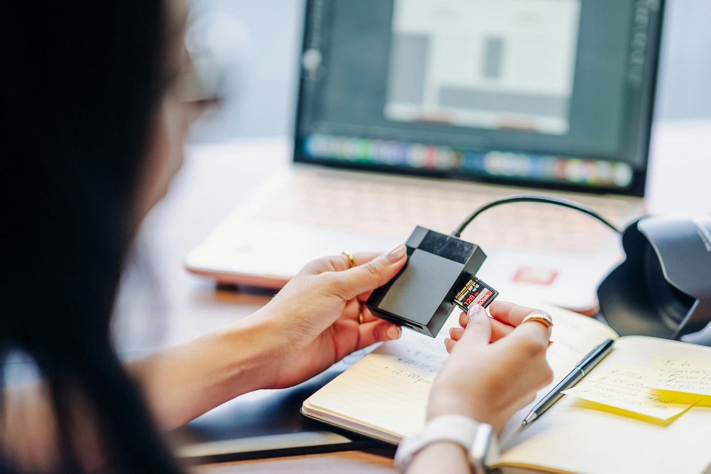 Person transferring data from an SD card to a computer as part of a digital workflow and cloud backup process. Photo by Julio Lopez on Unsplash