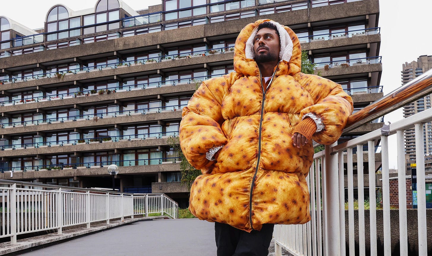A man striking a stylish pose whilst wearing Aldi UK's baked potato puffy jacket