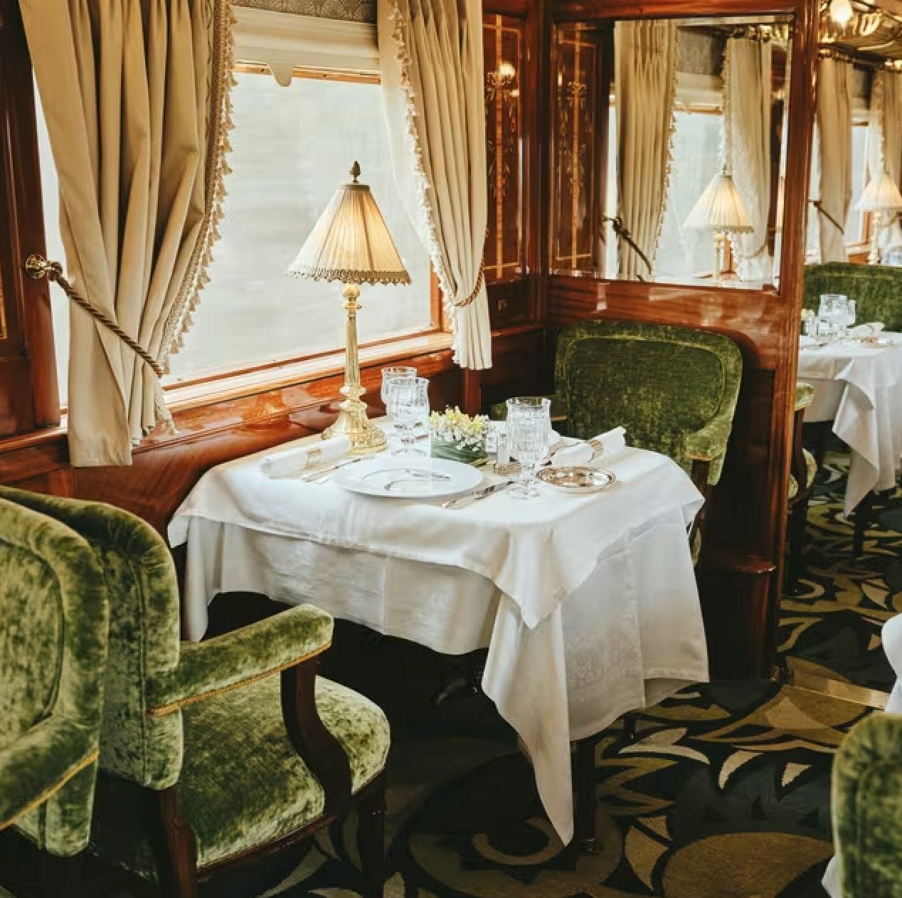 Elegant dining car aboard the Venice Simplon-Orient-Express set for dinner service. Elegant dining car aboard the Venice Simplon-Orient-Express set for dinner service.