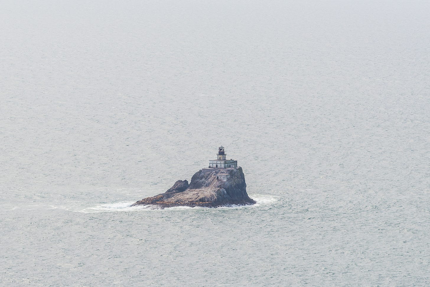 Lighthouse on a rock in the ocean.