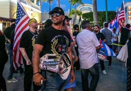 Man wears megaphone in crowd of those holding US flag