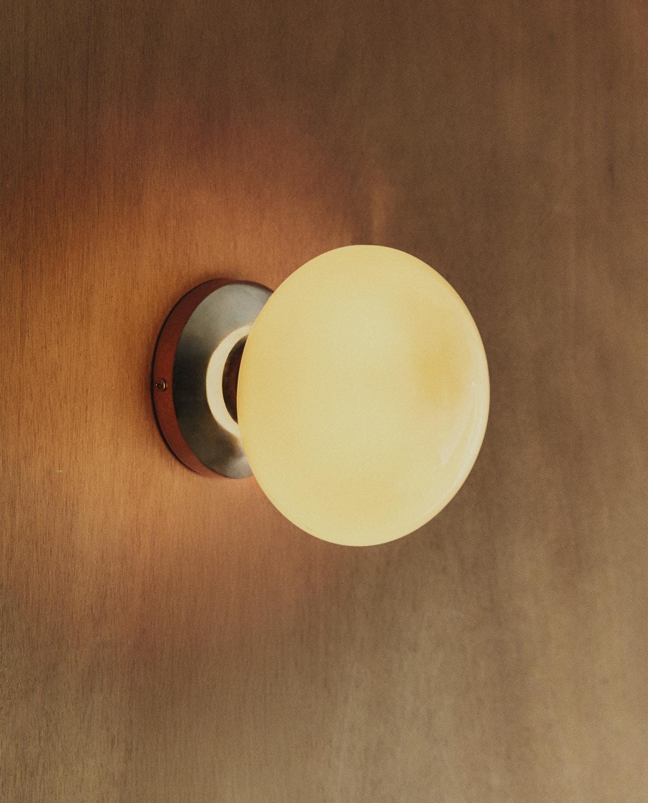 Spherical wall light in silver colour with minimalist design and G9 bulb, mounted on a circular metal base. Spherical wall light in silver colour with minimalist design and G9 bulb, mounted on a circular metal base.