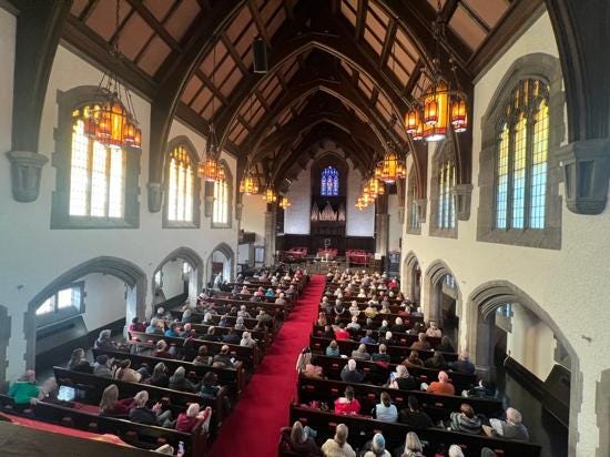 A group of people sitting in a church

Description automatically generated