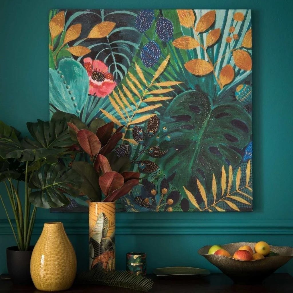 Vibrant tropical painting with monstera leaves and flowers displayed above decorative vases and fruit bowl.