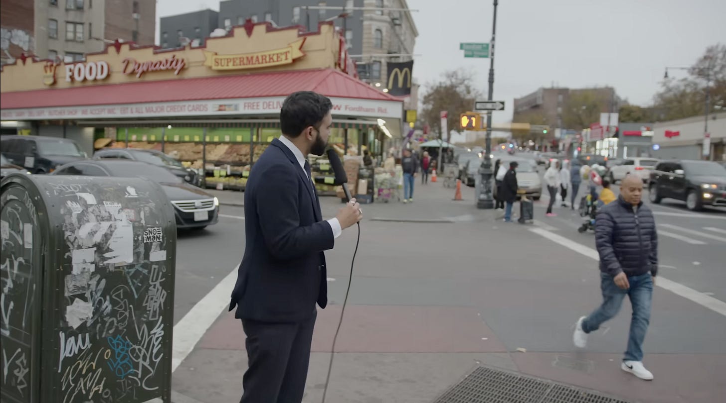A person in a suit holding a microphone

AI-generated content may be incorrect.