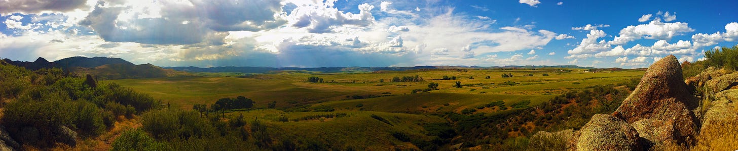 Expansive view of a valley floor with blue skies and clouds overhead Expansive view of a valley floor with blue skies and clouds overhead