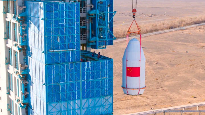 The first-stage, second-stage, and fairing for the Long March 2C launch vehicle heading to and being stacked ahead of the launch mission.