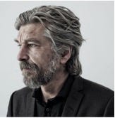 A person with a beard and mustache

Description automatically generated