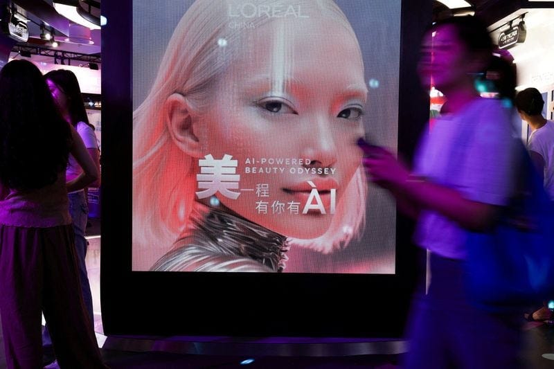 People walk past the L’Oreal booth during the World Artificial Intelligence Conference (WAIC) in Shanghai, China, July 17, 2026