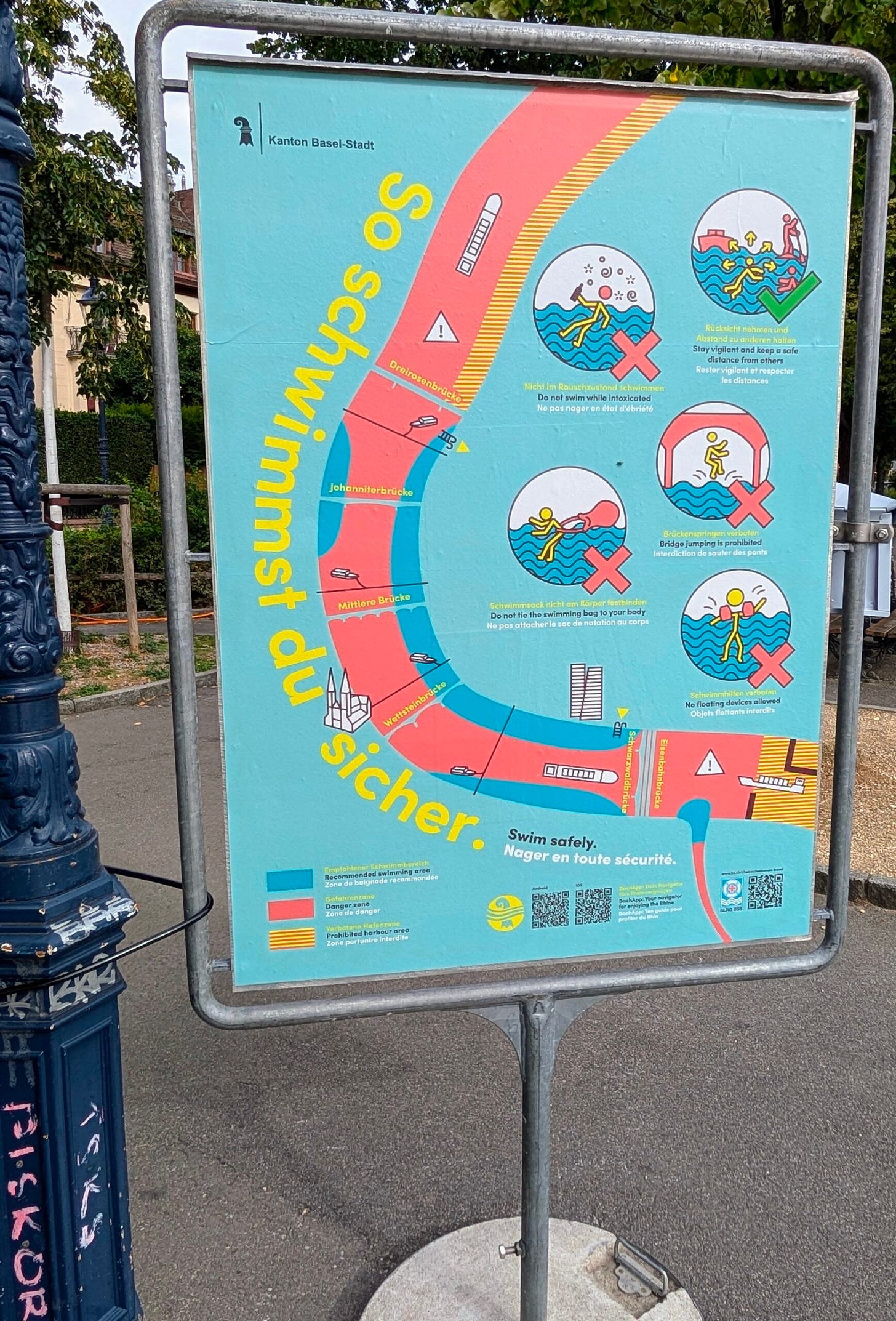 Large colorful, multilingual sign in Basel that provides instructions to those who want to swim the Rhine safely