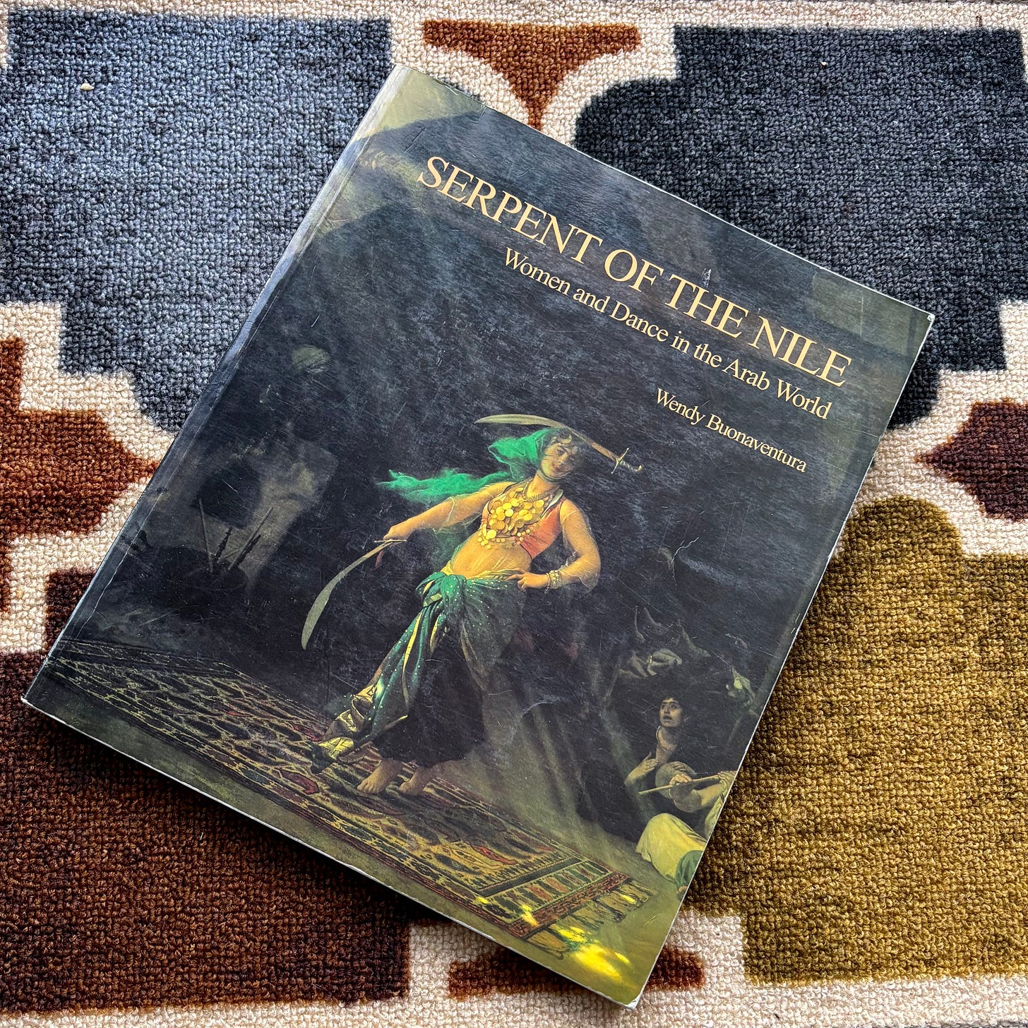 That gorgeous coffee table book, Serpent of the Nile, Women and Dance in the Arab World by Wendy Buonaventura. The cover shows a smoky, fantastical setting where a dancer wields two sabers, one on her head. That gorgeous coffee table book, Serpent of the Nile, Women and Dance in the Arab World by Wendy Buonaventura. The cover shows a smoky, fantastical setting where a dancer wields two sabers, one on her head.