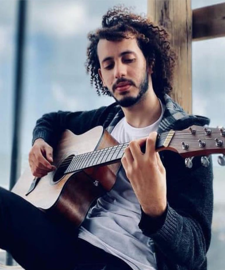 A person playing a guitar

Description automatically generated