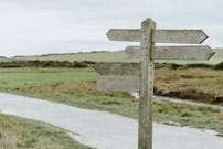 A wooden signpost in the countryside.