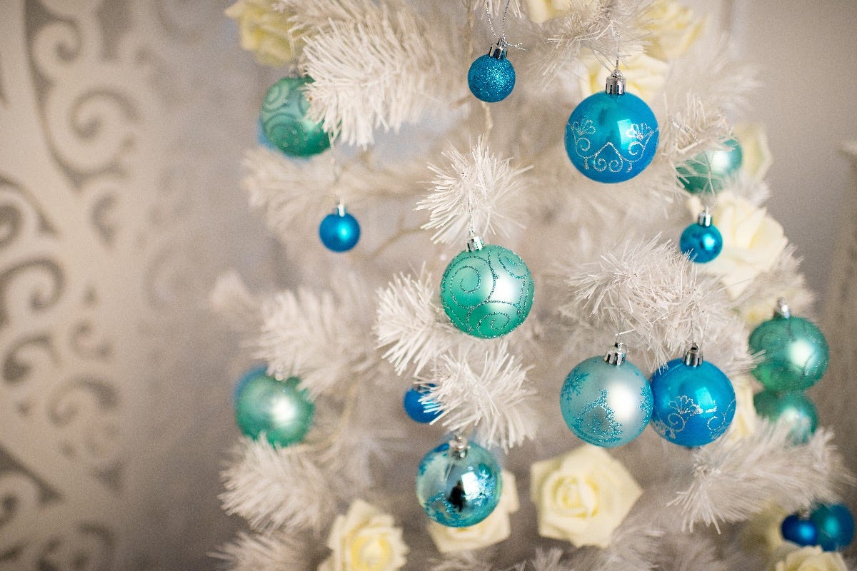 White artificial christmas tree with blue baubles on it White artificial christmas tree with blue baubles on it
