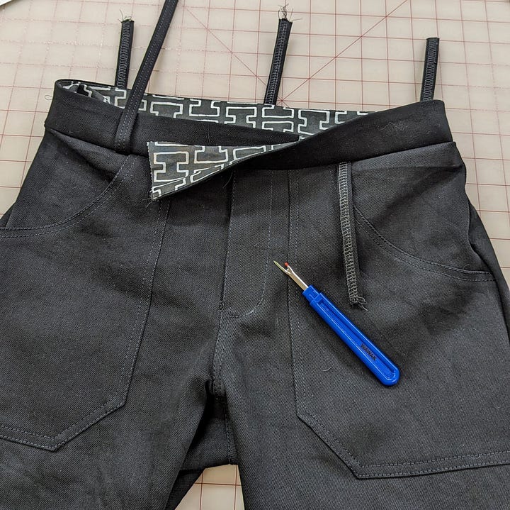 Bolts of denim and a pair of jeans in progress