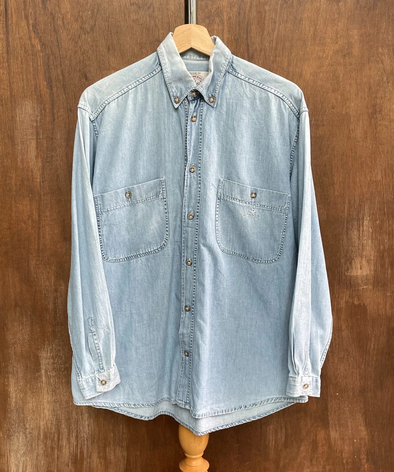 Light blue denim ARMANI JEANS 90s shirt with western shirt tag, two chest flap pockets, and button-down collar. Light blue denim ARMANI JEANS 90s shirt with western shirt tag, two chest flap pockets, and button-down collar.