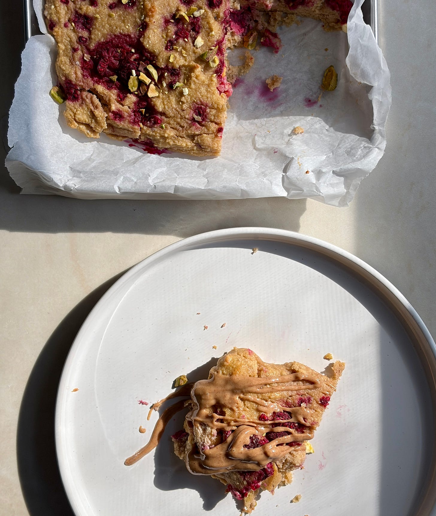 Raspberry pistachio gluten-free pancake bake with almond butter drizzled on top