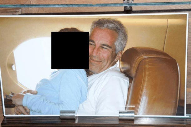 This redacted photo released by the U.S. Department of Justice shows a framed photograph of Jeffrey Epstein with a person on his lap, documented on Aug. 12, 2019, during a search of his home on Little St. James island in the U.S. Virgin Islands