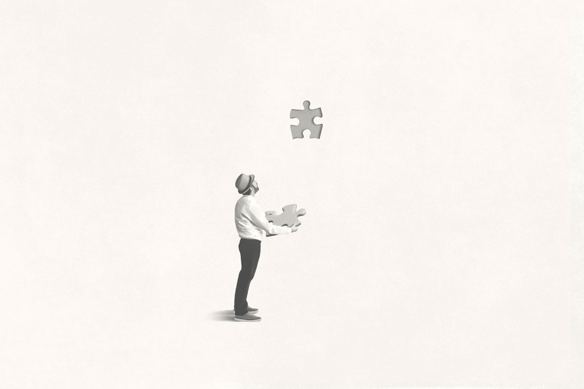 Man Puzzling over Two Puzzle Pieces