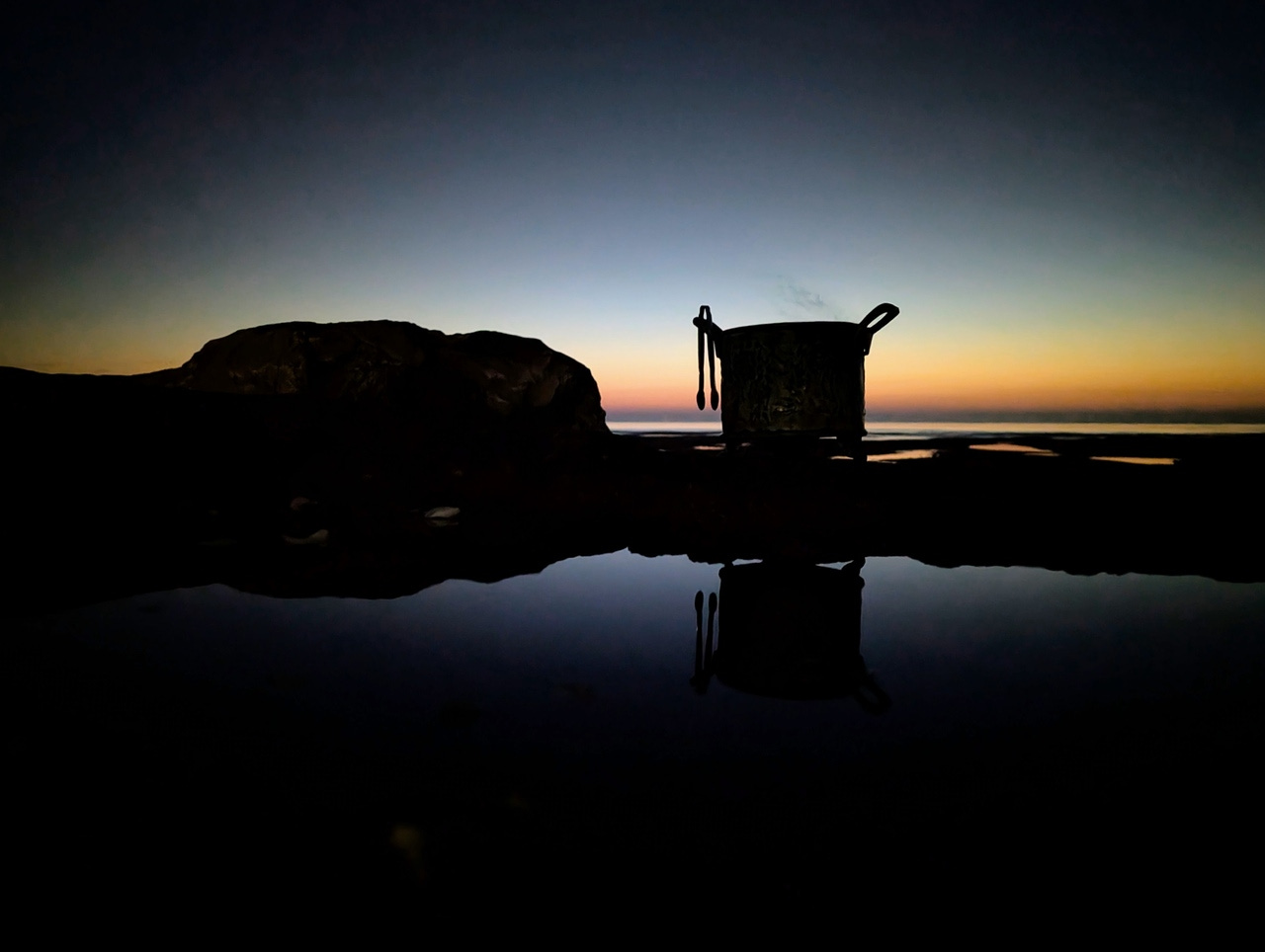 Cauldron by a rockpool at sunset