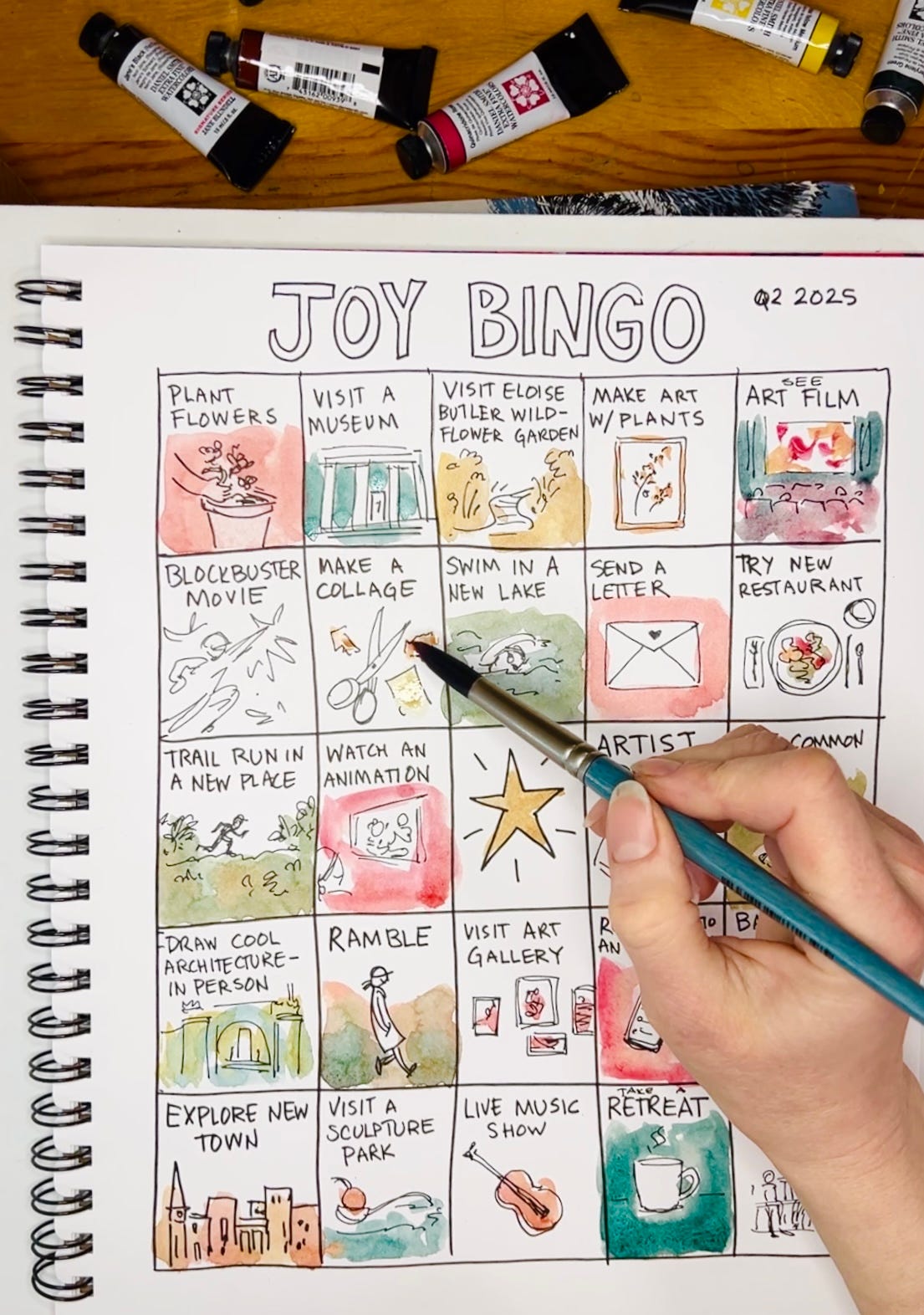 Painting a joy bingo board with watercolor by cartoonist K. Woodman-Maynard