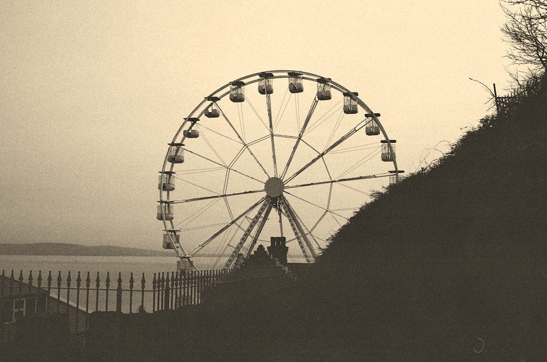 Ferris wheel by the water on a cloudy day
