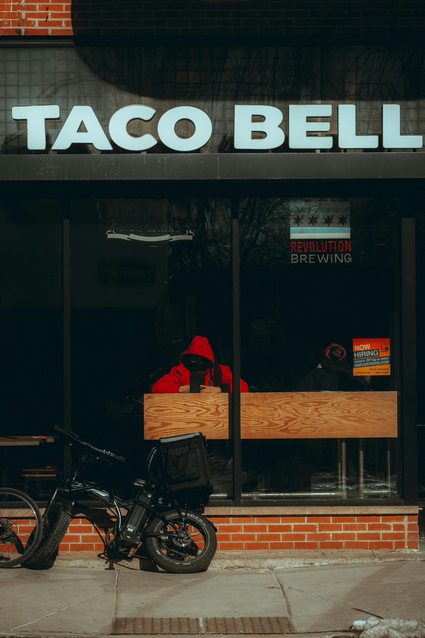 taco bell exterior with person eating inside taco bell exterior with person eating inside