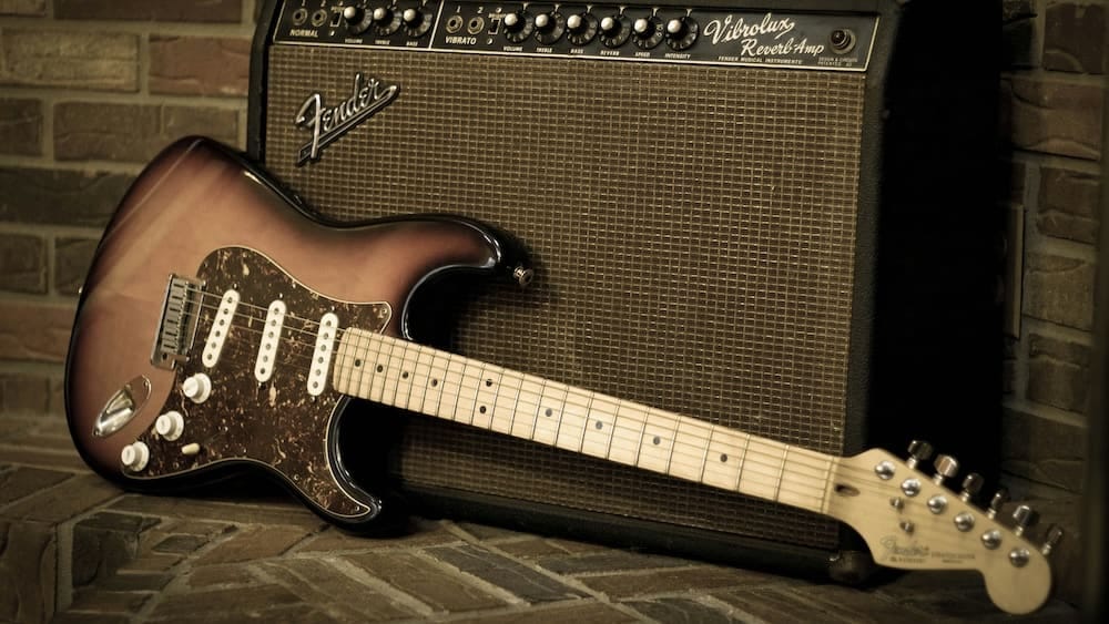 Electric guitar leaning against a vintage amplifier Electric guitar leaning against a vintage amplifier