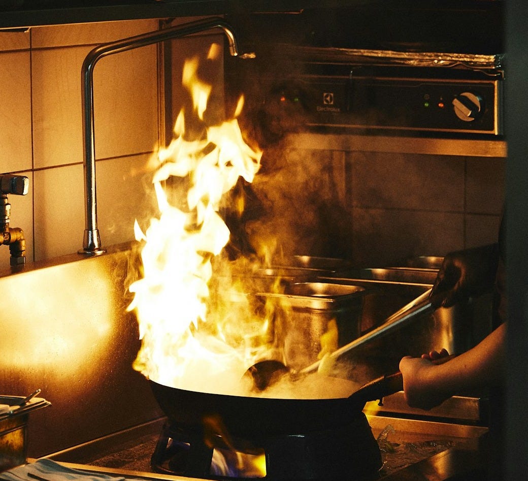 A large pot on a stove with flames in it