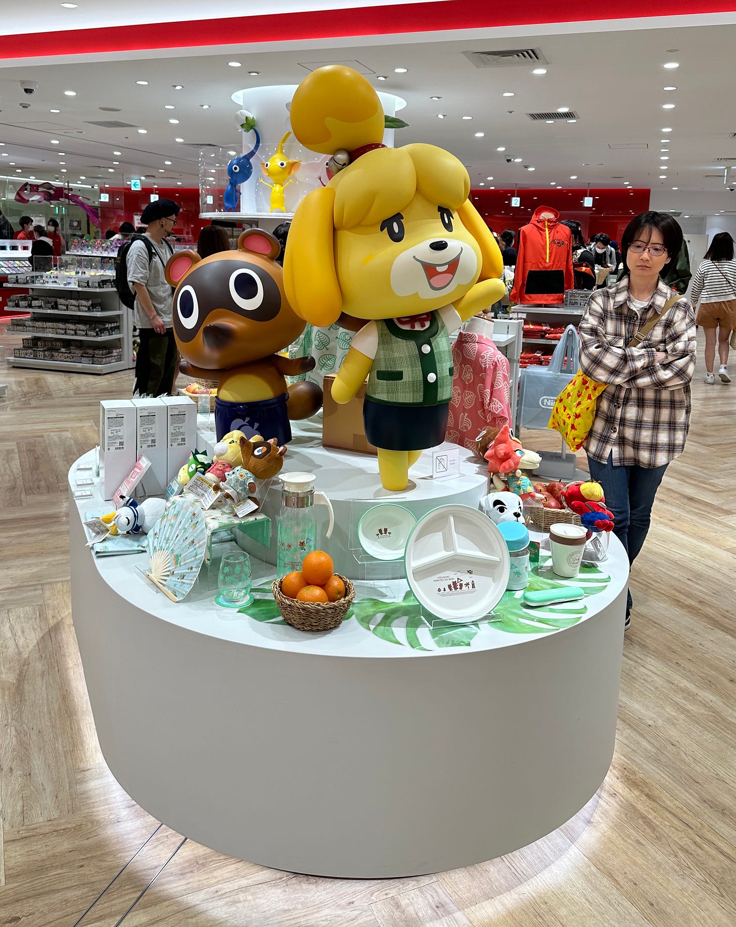 Interior of Nintendo Store featuring a display of Animal Crossing merchandise and large figures of Isabelle and Timmy (or Tommy, they look the same)