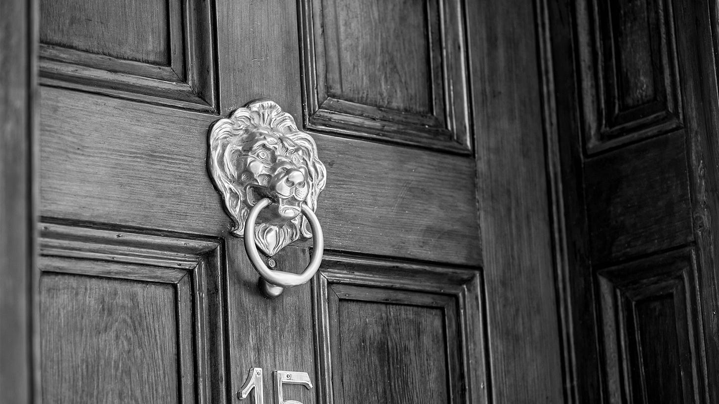 Magnificent lion's head door knocker on an old wooden door