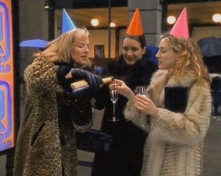 This may contain: three women standing around each other with party hats on This may contain: three women standing around each other with party hats on