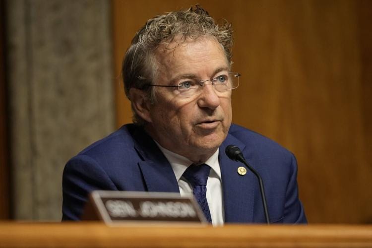 Sen. Rand Paul in a blue suit speaks into a microphone during the Senate hearing. Sen. Rand Paul in a blue suit speaks into a microphone during the Senate hearing.