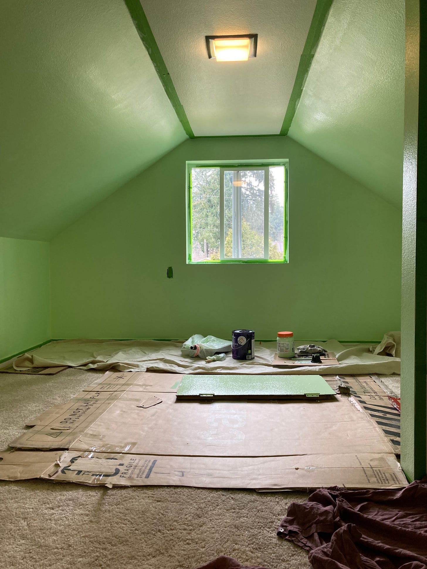 The same green room pictured at the beginning of this post, but while it was being painted. There's a big piece of cardboard on the board, and painting supplies.