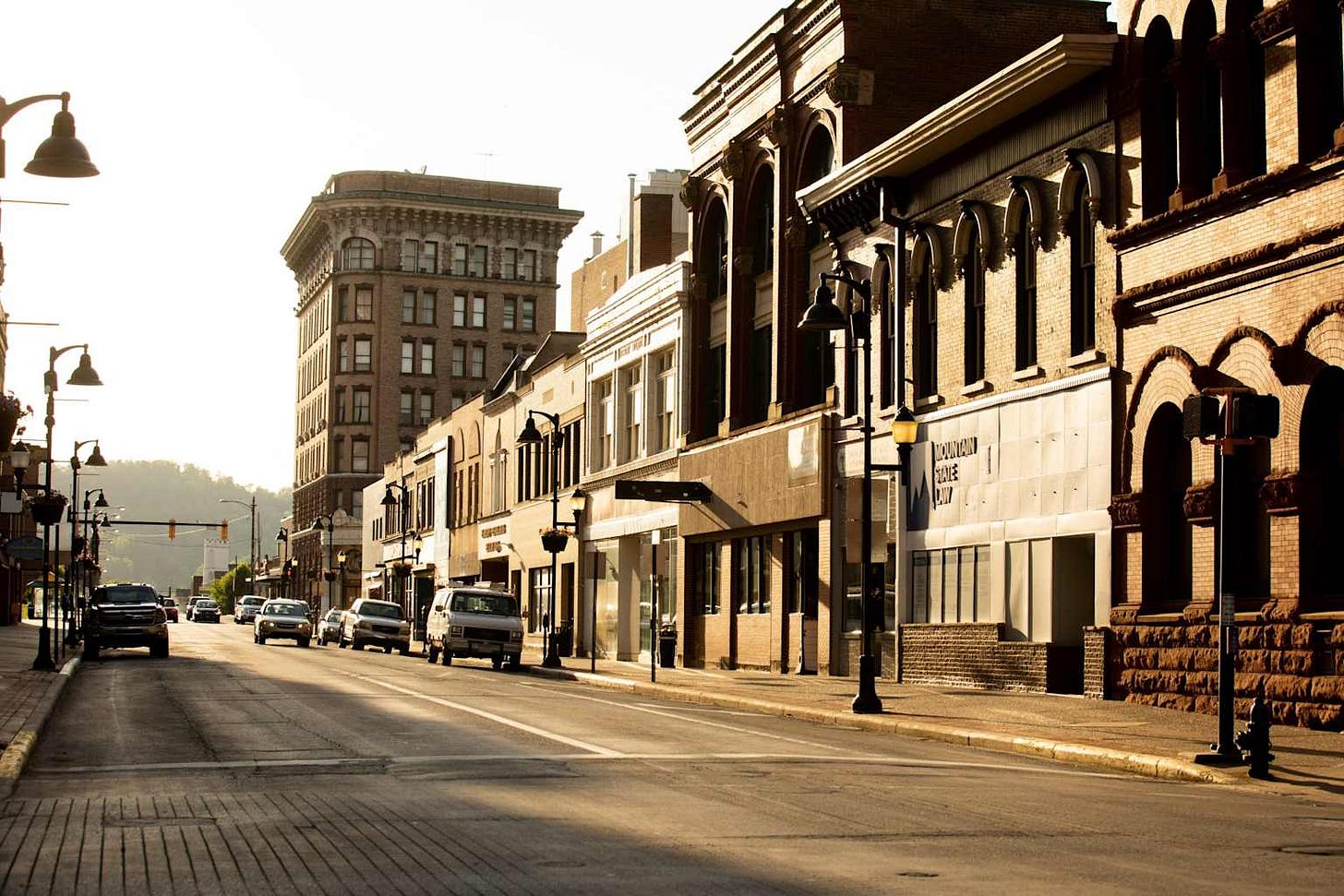 Historic main street in a West Virginia town featuring local businesses under a warm sunlight